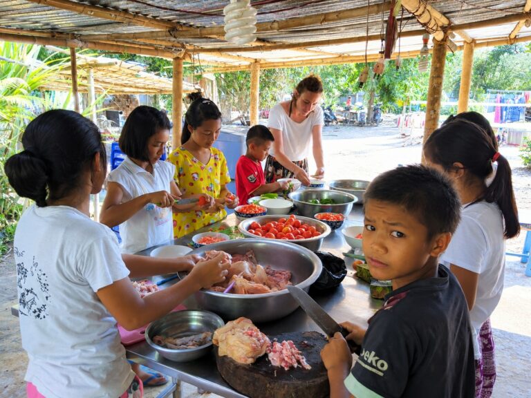 Children and adults preparing a meal together at the orphanage in Myanmar