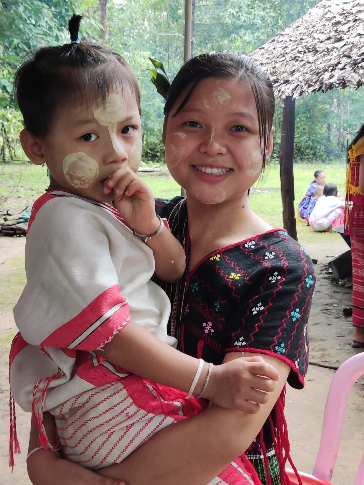 Femme portant un enfant au sein d’une communauté